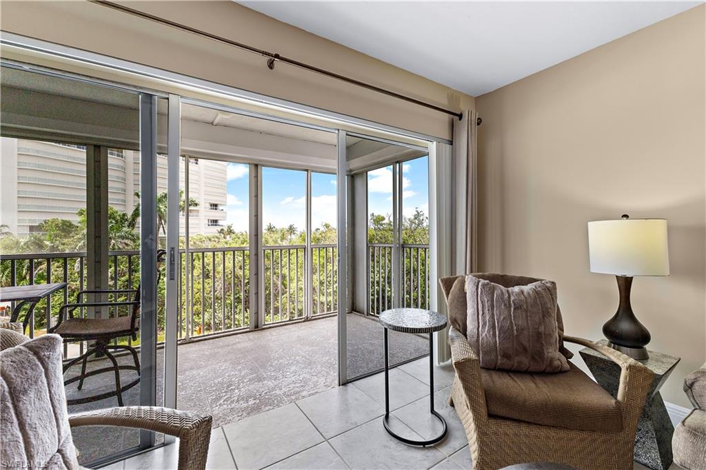 1 Bluebill Avenue, Unit 409 Naples, FL 34108 - Photo 13 of 17 a living room with furniture and a floor to ceiling window
