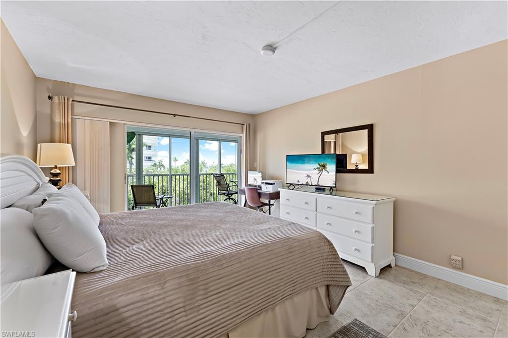 1 Bluebill Avenue, Unit 409 Naples, FL 34108 - Photo 16 of 17 a bedroom with a bed and a flat screen tv