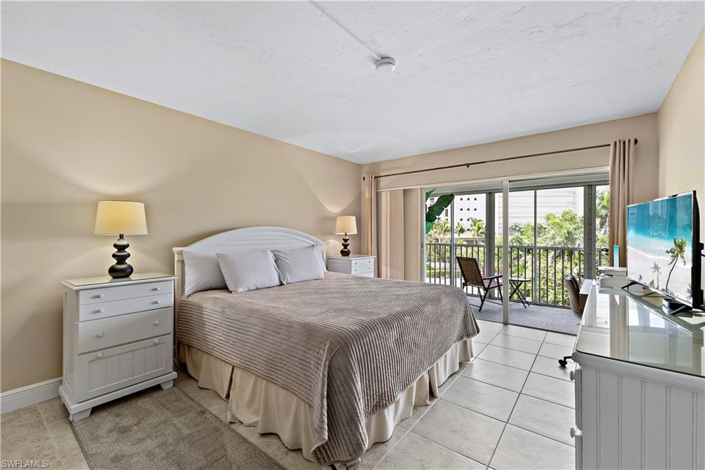 1 Bluebill Avenue, Unit 409 Naples, FL 34108 - Photo 17 of 17 a bedroom with a bed and large windows