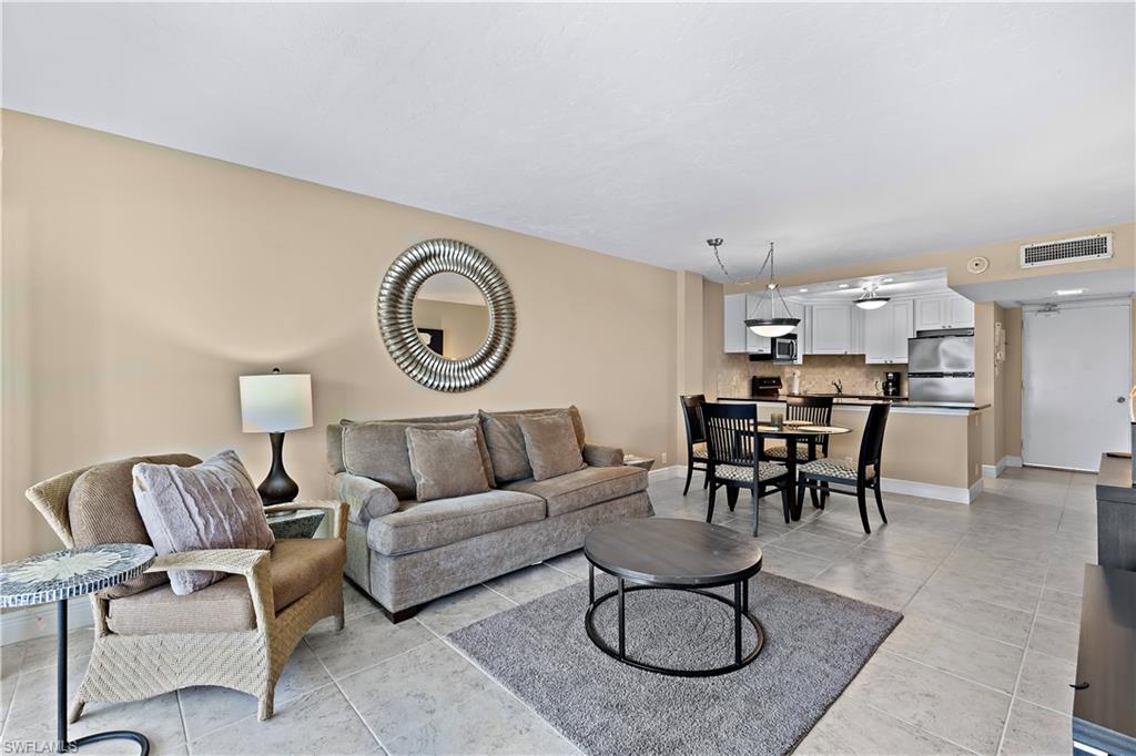 1 Bluebill Avenue, Unit 409 Naples, FL 34108 - Photo 5 of 17 a living room with furniture a rug and a lamp