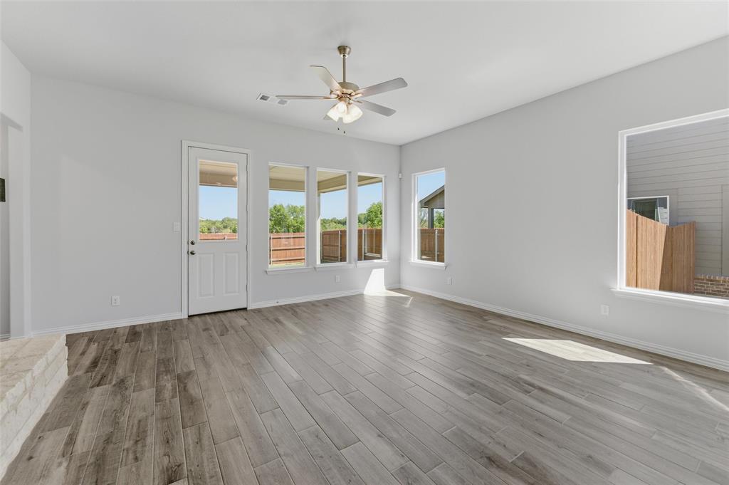 1225 Sabine River Lane Springtown, TX 76082 - Photo 9 of 25 Unfurnished living room featuring ceiling fan and light wood-type flooring