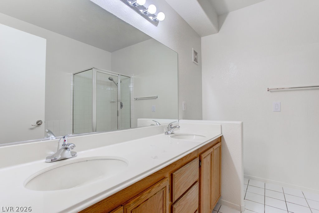 2201 Ramsgate Drive, Unit 326 Henderson, NV 89074 - Photo 33 of 44 Full bathroom featuring a stall shower, double vanity, and light tile patterned floors