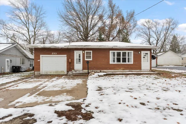 a view of a house with a yard covered in snow