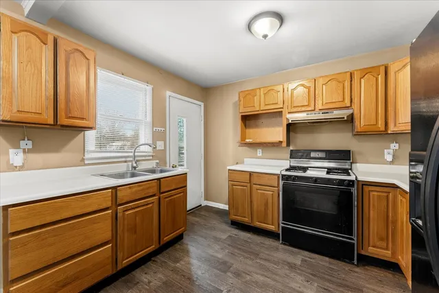 a kitchen with stainless steel appliances granite countertop a stove a sink and a refrigerator