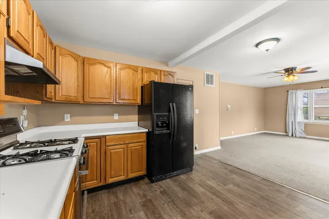 a kitchen with a refrigerator and a stove top oven