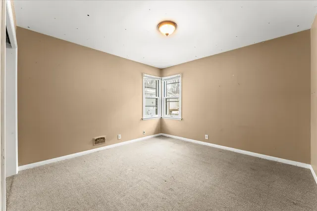 an empty room with windows and closet