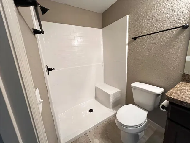 a white toilet sitting next to a bathroom sink and a shower