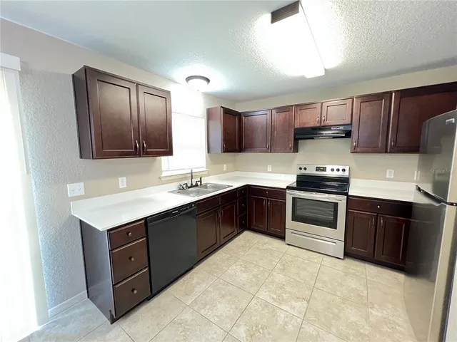 a kitchen with kitchen island granite countertop a stove microwave and cabinets
