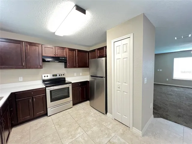 a kitchen with stainless steel appliances granite countertop a refrigerator stove and sink