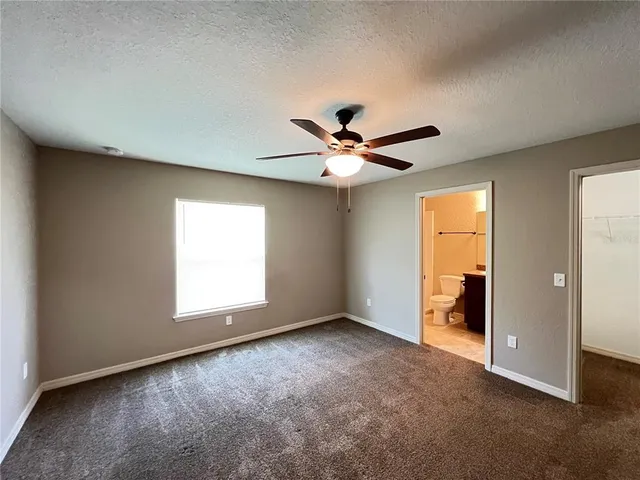 an empty room with closet and windows