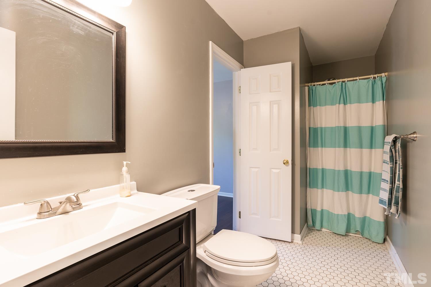 3604 Norway Court Raleigh, NC 27616 - Photo 15 of 26 a bathroom with a sink a toilet and shower