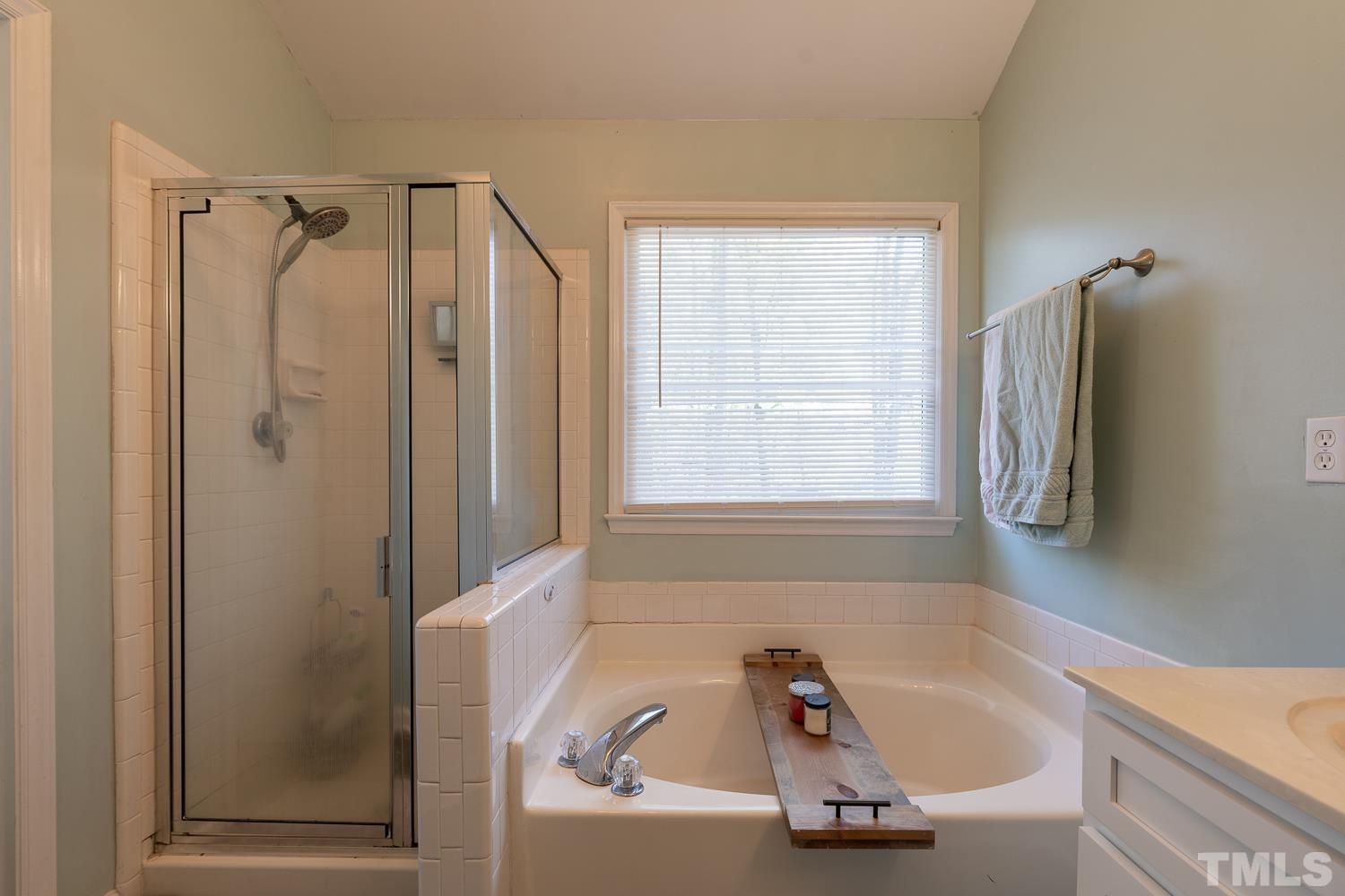 3604 Norway Court Raleigh, NC 27616 - Photo 22 of 26 a bathroom with a tub a window and a shower