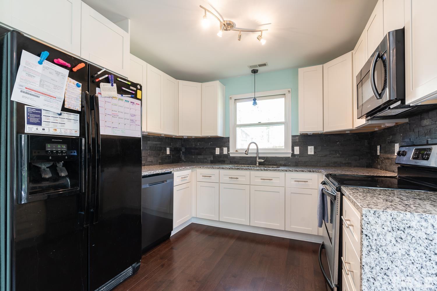 3604 Norway Court Raleigh, NC 27616 - Photo 5 of 26 a kitchen with stainless steel appliances granite countertop a refrigerator a sink dishwasher a stove and white cabinets
