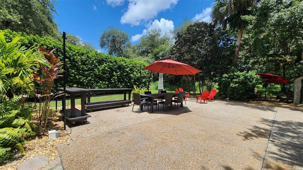 389 Longhorn Drive River Ranch, FL 33867 - Photo 3 of 11 a view of a patio with a table and chairs under an umbrella with a small yard