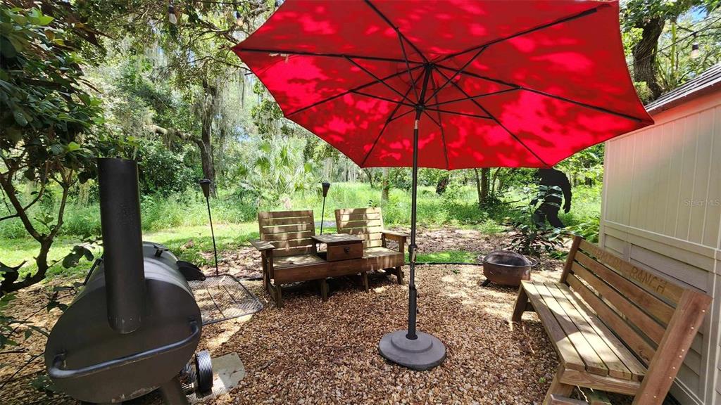 389 Longhorn Drive River Ranch, FL 33867 - Photo 4 of 11 a view of a patio with chairs and table under an umbrella