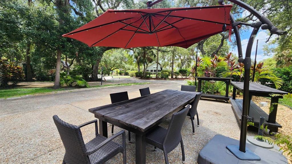 389 Longhorn Drive River Ranch, FL 33867 - Photo 9 of 11 a view of a patio with table and chairs under an umbrella