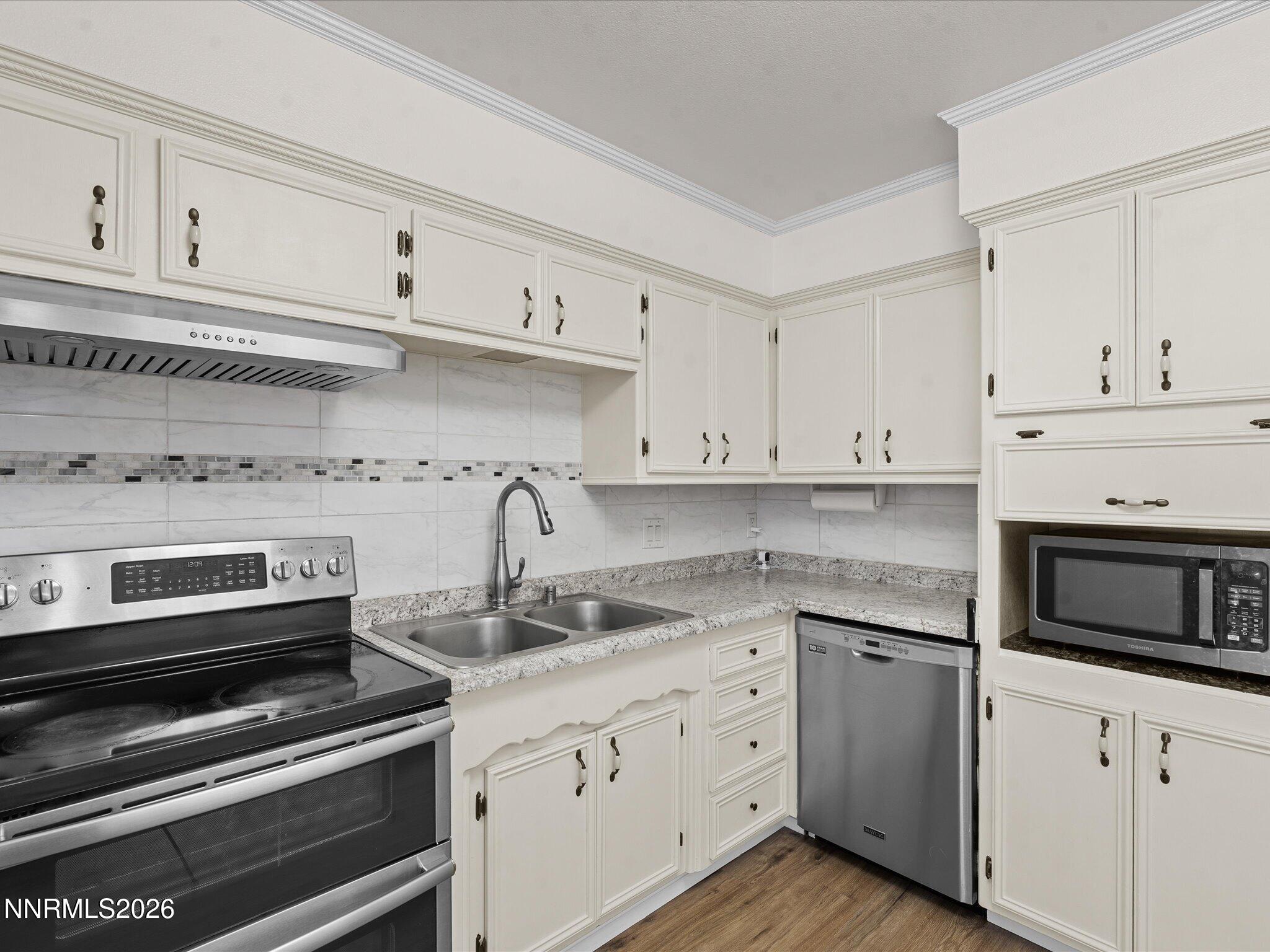 1540 Tyler Way Sparks, NV 89431 - Photo 12 of 35 a kitchen with granite countertop white cabinets and stainless steel appliances