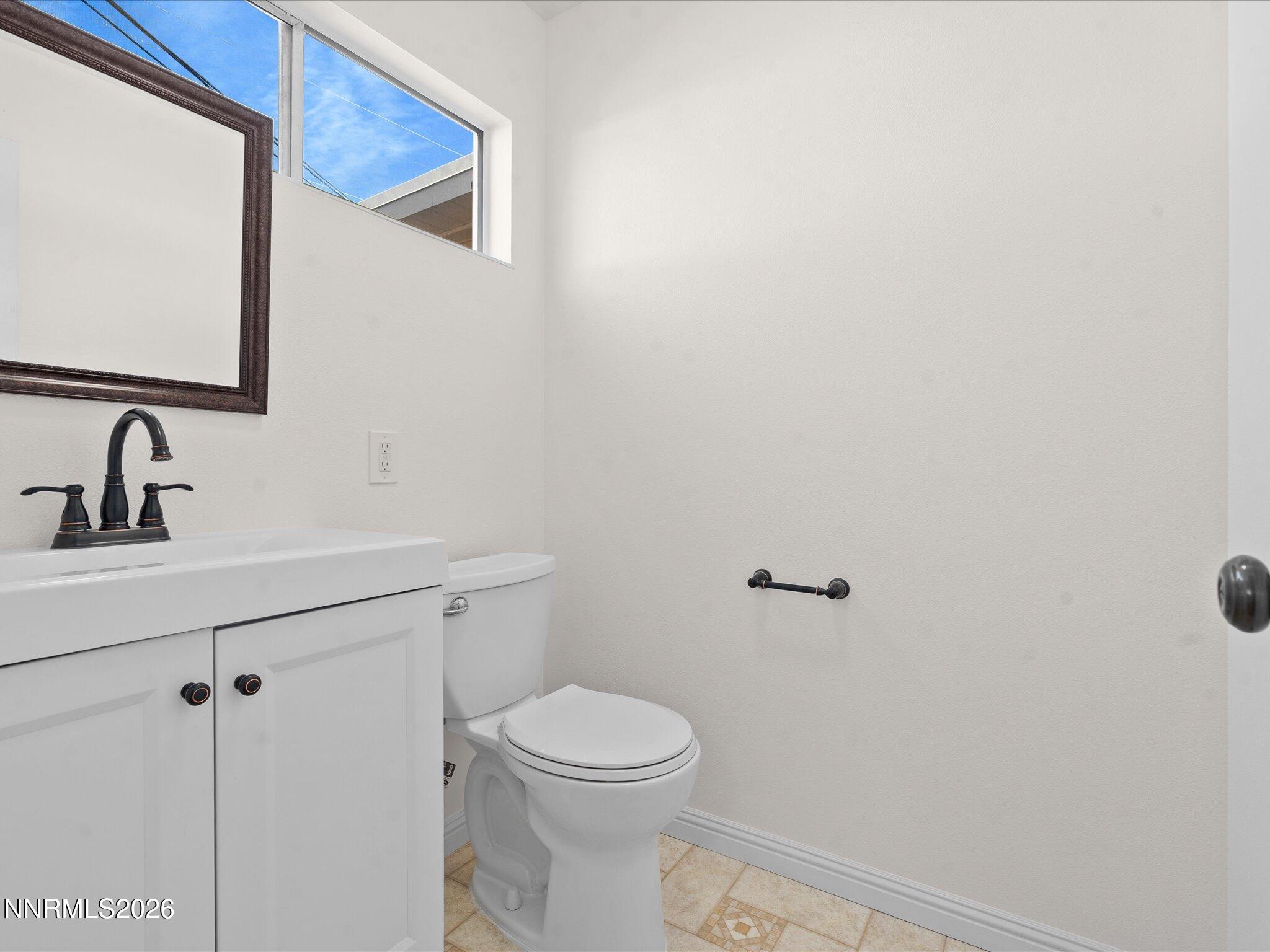 1540 Tyler Way Sparks, NV 89431 - Photo 20 of 35 a bathroom with a toilet a sink and mirror