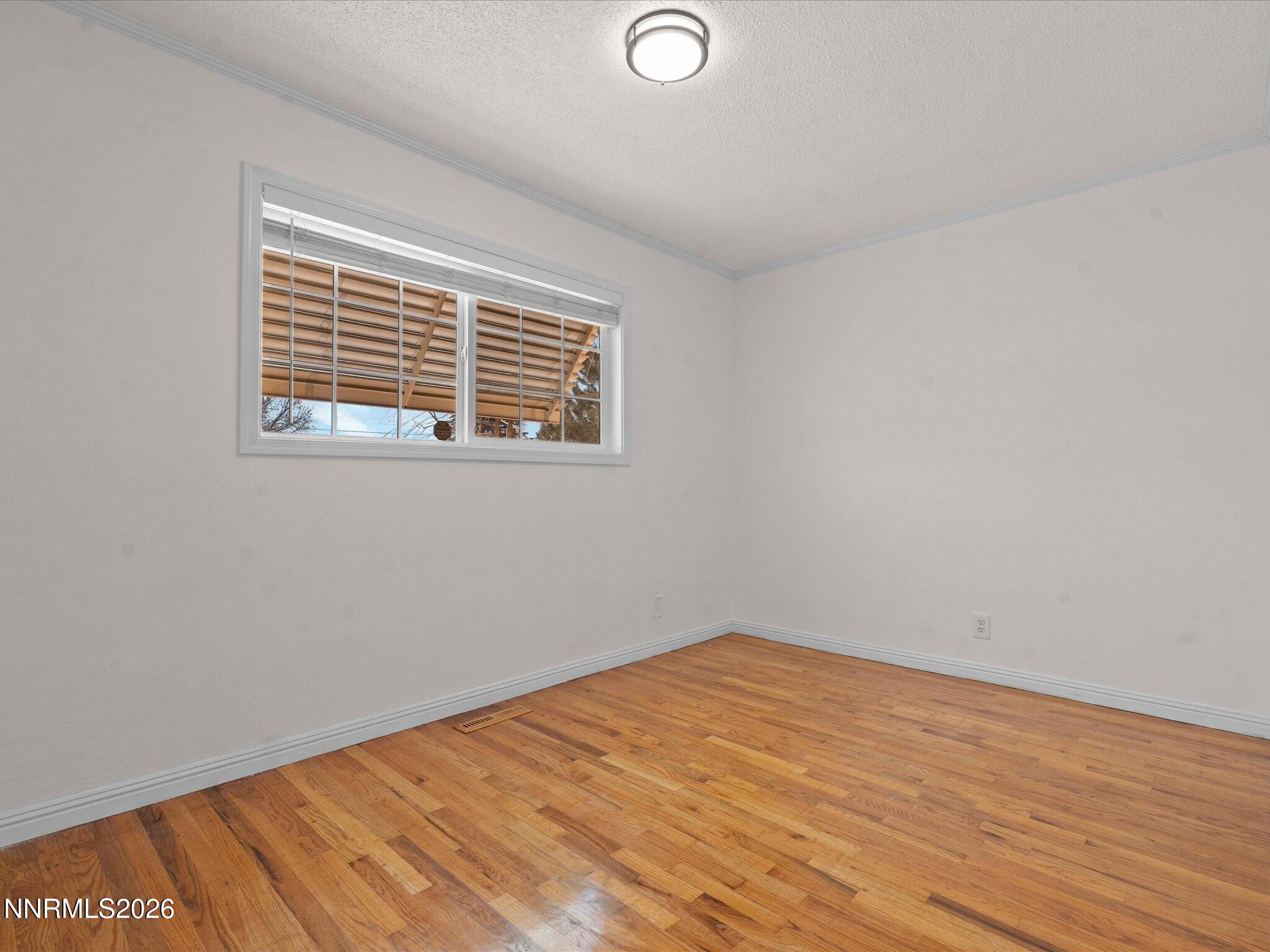 1540 Tyler Way Sparks, NV 89431 - Photo 24 of 35 a view of an empty room with wooden floor and a window