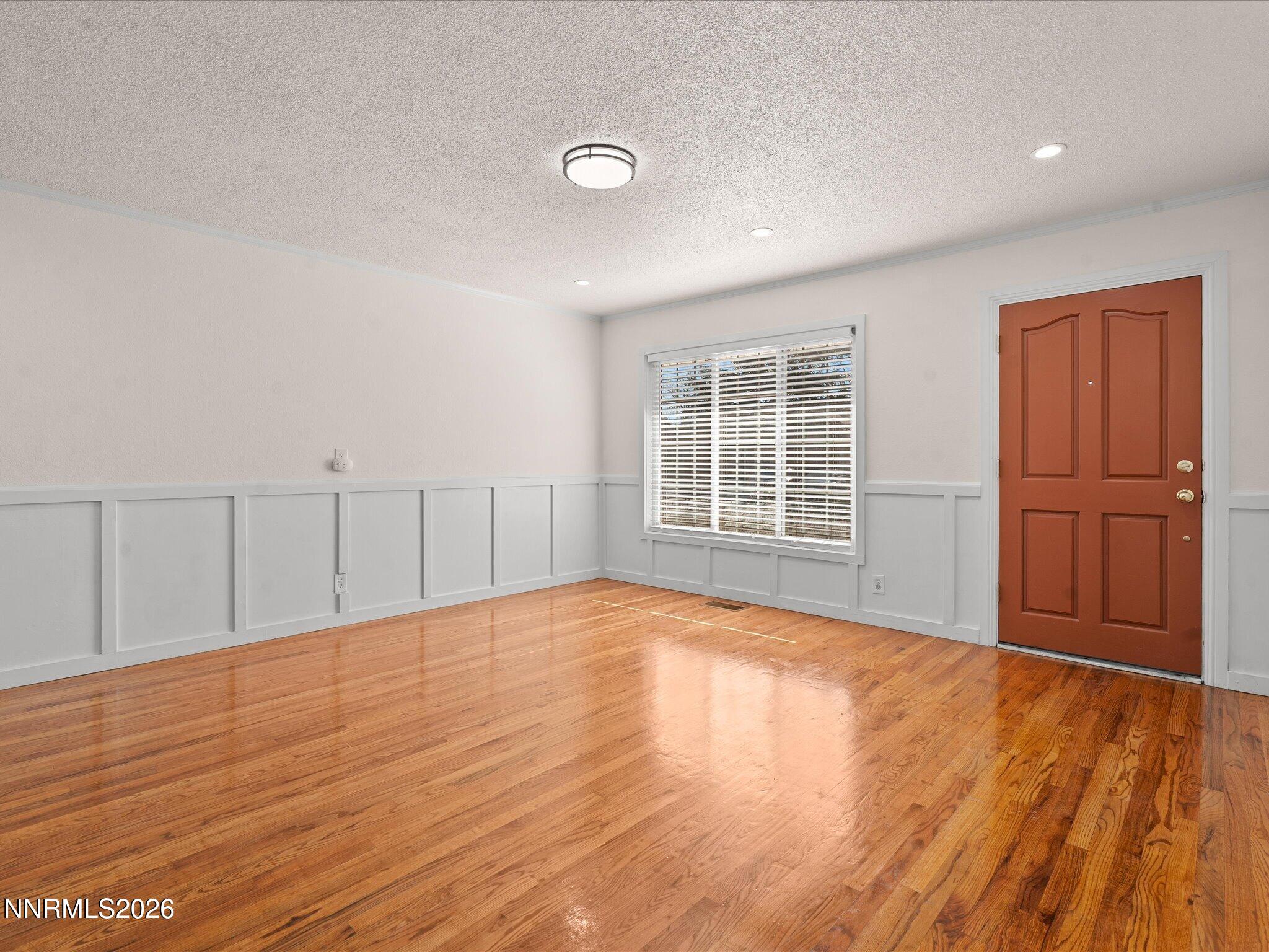 1540 Tyler Way Sparks, NV 89431 - Photo 6 of 35 a view of an empty room with wooden floor and a window