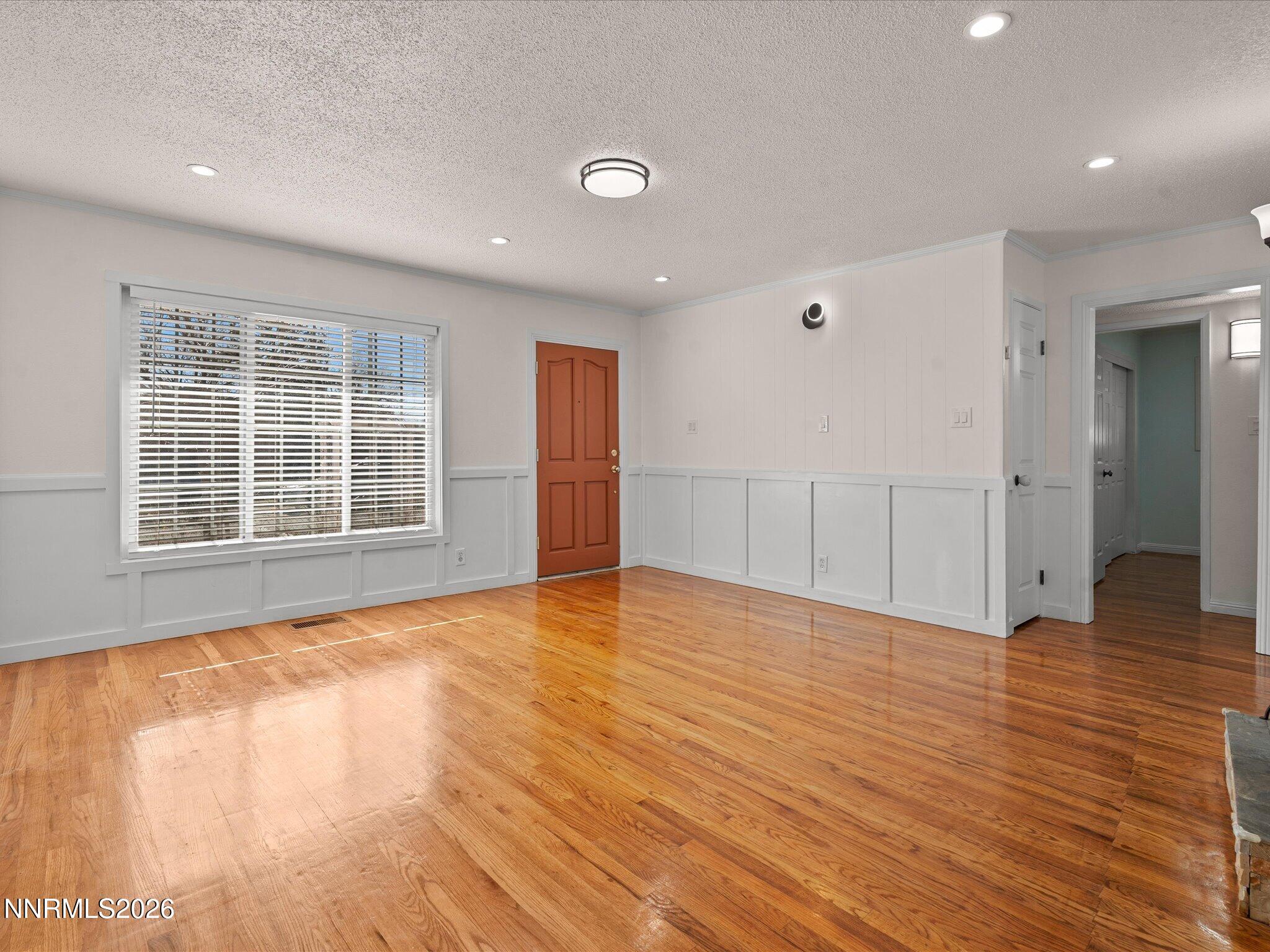 1540 Tyler Way Sparks, NV 89431 - Photo 7 of 35 a view of an empty room with wooden floor and a window
