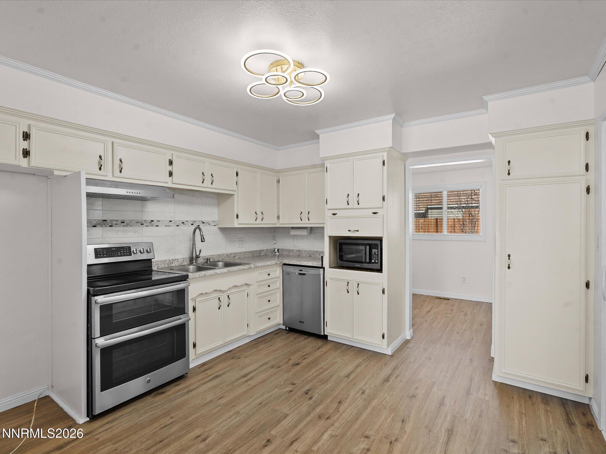 1540 Tyler Way Sparks, NV 89431 - Photo 9 of 35 a kitchen with cabinets wooden floor and stainless steel appliances