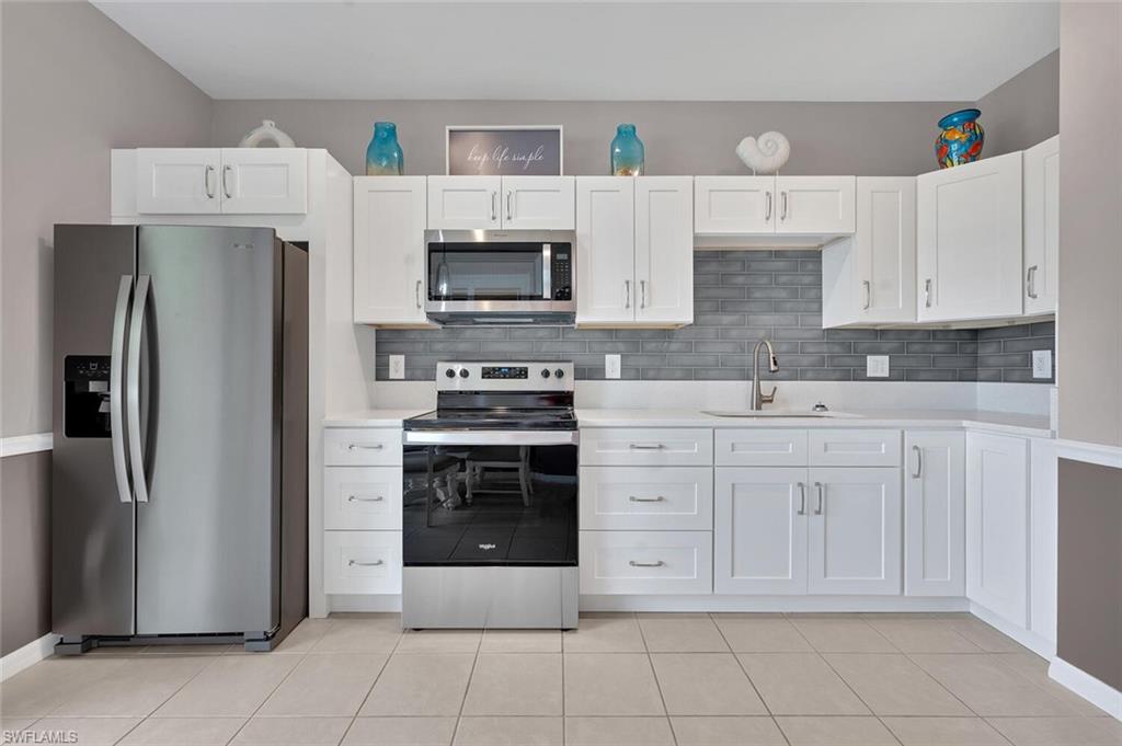 17528 Cherry Ridge Lane Fort Myers, FL 33967 - Photo 6 of 18 a kitchen with white cabinets and stainless steel appliances