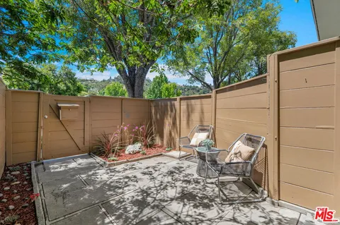 a backyard of a house with table and chairs