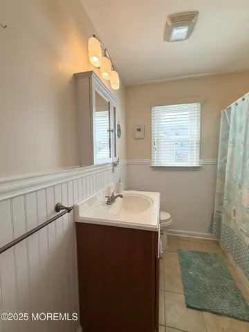 a bathroom with a sink a toilet and mirror