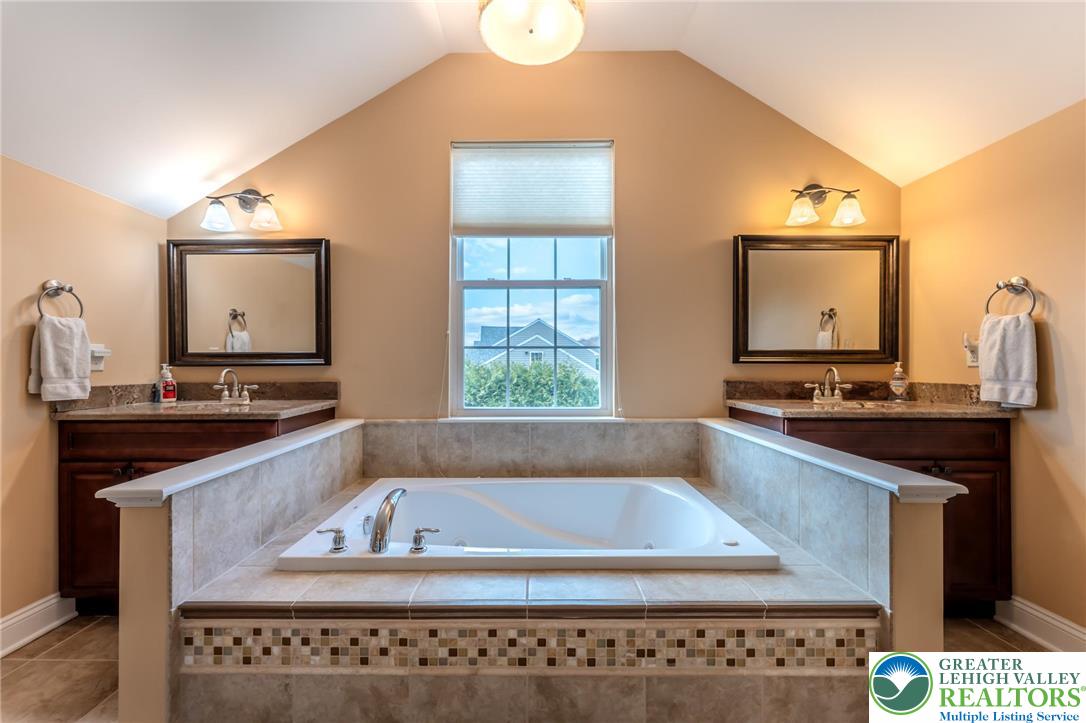 3505 Woodbyne Road Hellertown, PA 18055 - Photo 31 of 66 a bathroom with a granite countertop sink a mirror and a bathtub