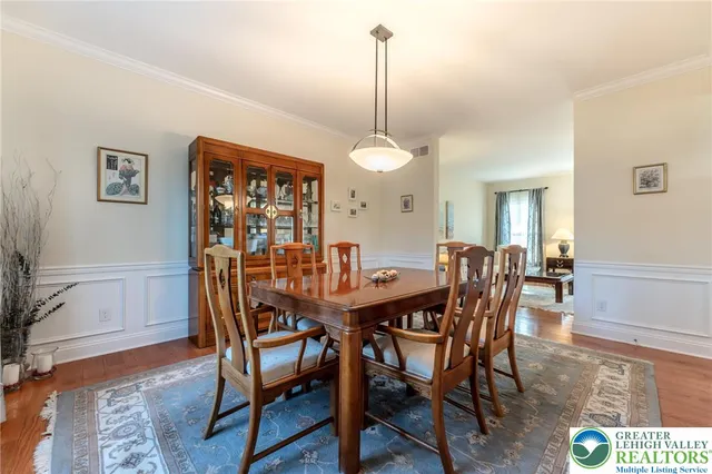 a open kitchen with stainless steel appliances granite countertop a stove top oven a sink a dining table and chairs with wooden floor