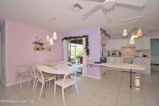 a view of a dining room with furniture and a chandelier fan