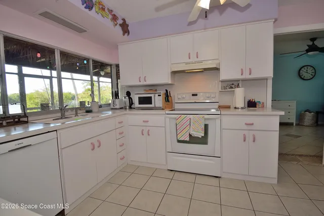 a kitchen with cabinets appliances a sink and a window