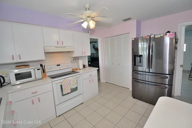 a kitchen with stainless steel appliances white cabinets and a refrigerator