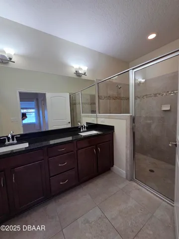 a bathroom with a granite countertop sink a mirror and a shower
