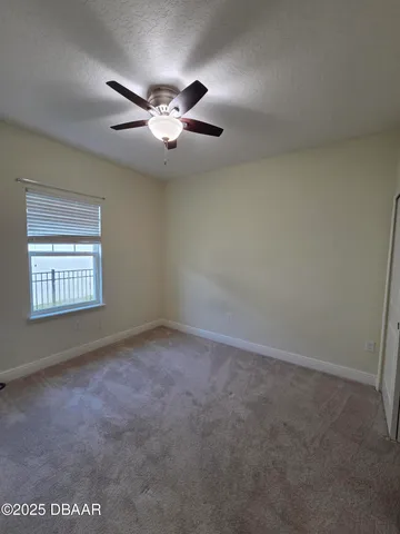 an empty room with windows and fan