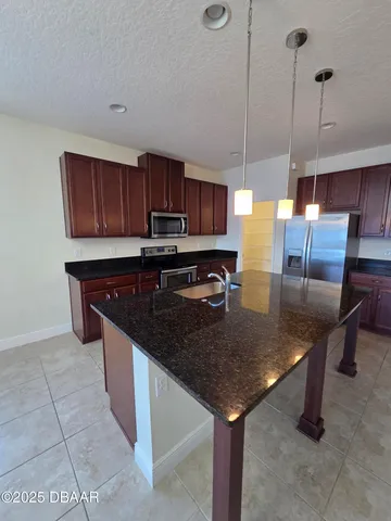 a kitchen with stainless steel appliances granite countertop a sink a counter space and cabinets