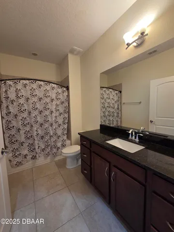 a bathroom with a granite countertop sink a toilet and a mirror
