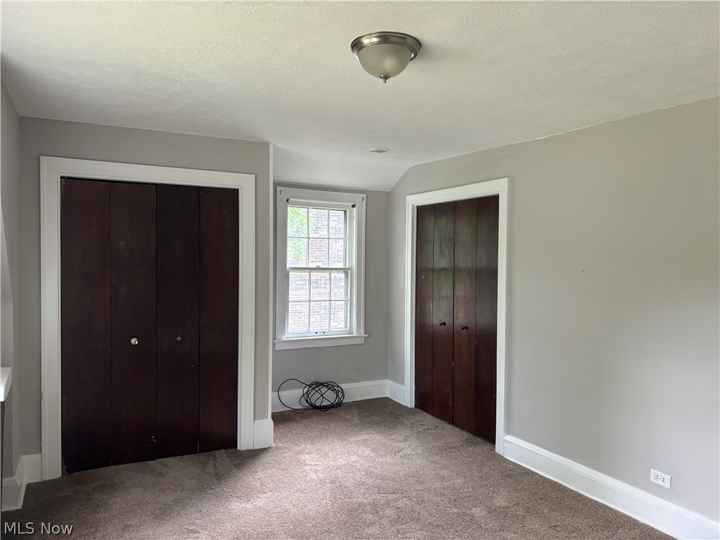 3030 Keswick Road Cleveland, OH 44120 - Photo 14 of 15 Unfurnished bedroom featuring carpet flooring, vaulted ceiling, and a textured ceiling
