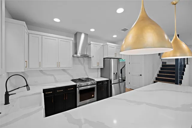 a kitchen with stainless steel appliances kitchen island granite countertop a stove a sink and a refrigerator