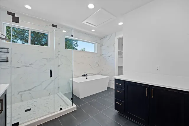 a spacious bathroom with a bathtub sink and mirror