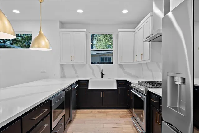 a kitchen with granite countertop a sink stainless steel appliances and cabinets