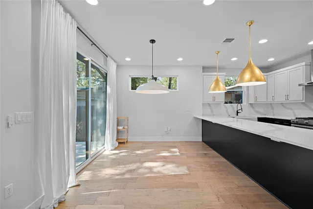 a view of kitchen with stainless steel appliances granite countertop a refrigerator and a sink