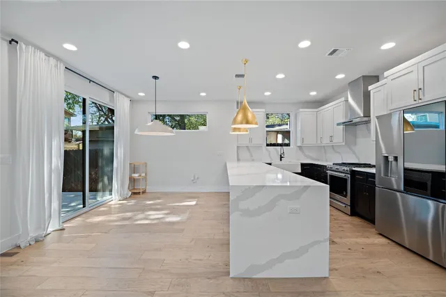 a large kitchen with stainless steel appliances kitchen island a large counter top and a sink