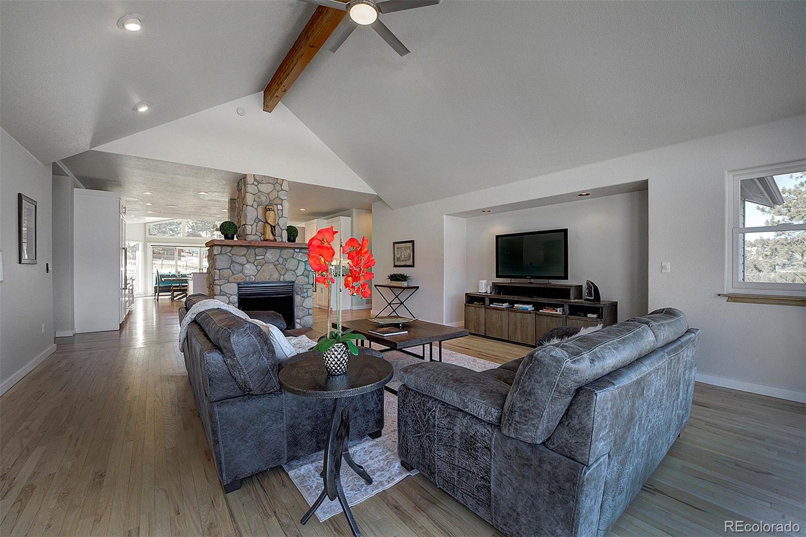 5371 Hazel Road Evergreen, CO 80439 - Photo 20 of 47 a living room with furniture a flat screen tv and a fireplace