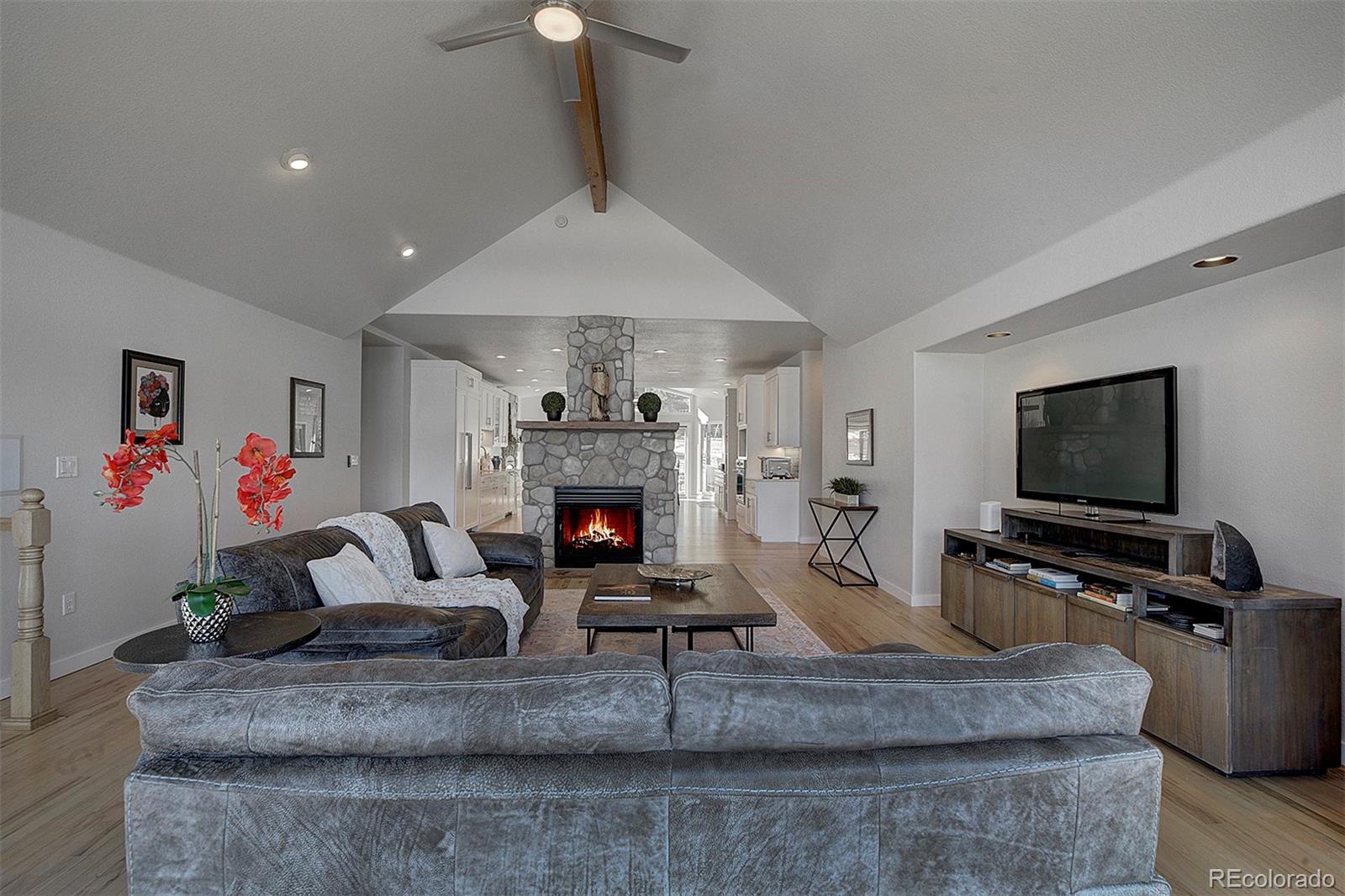 5371 Hazel Road Evergreen, CO 80439 - Photo 21 of 47 a living room with furniture a flat screen tv and a fireplace