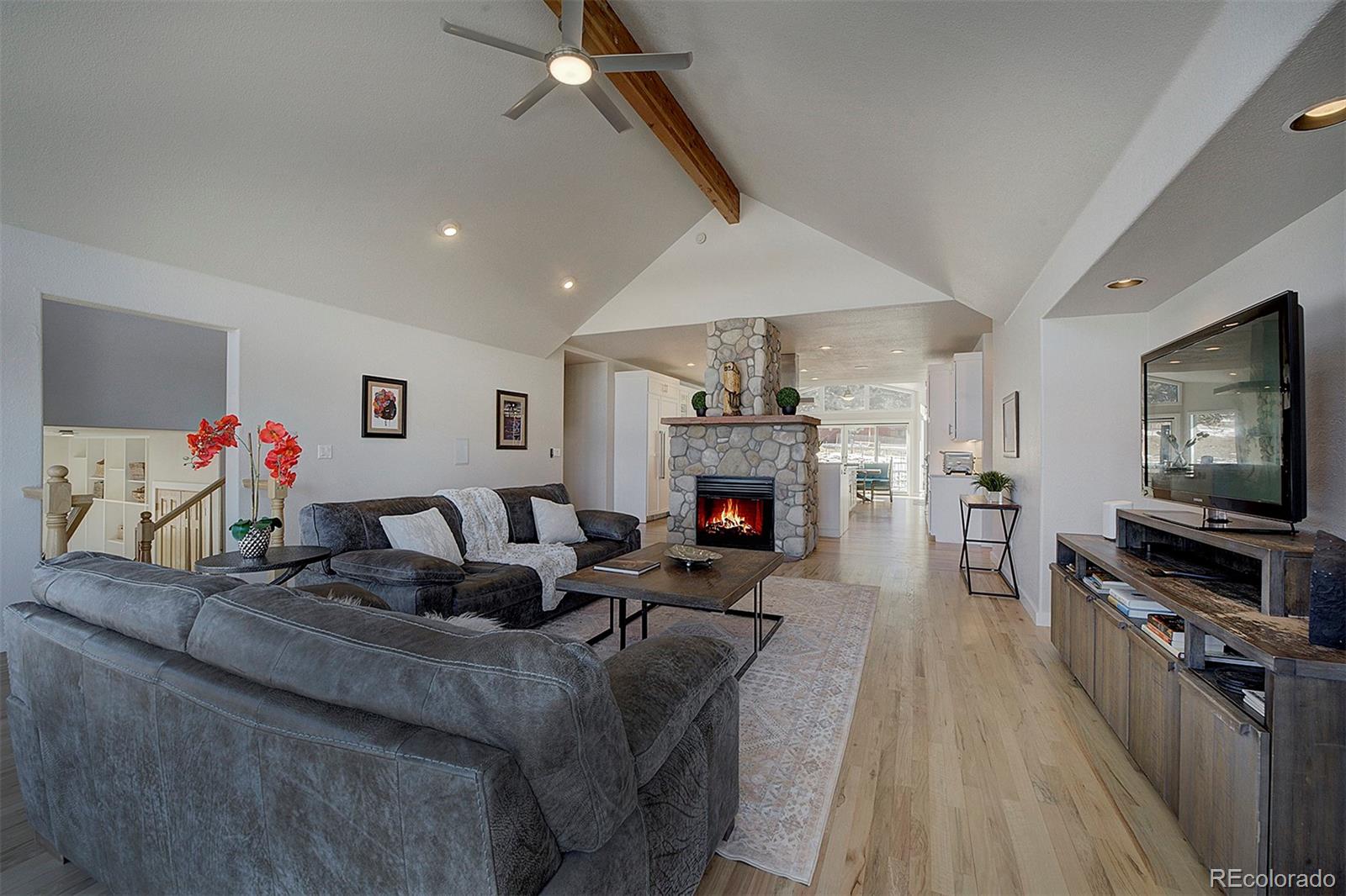 5371 Hazel Road Evergreen, CO 80439 - Photo 22 of 47 a living room with furniture a flat screen tv and a fireplace