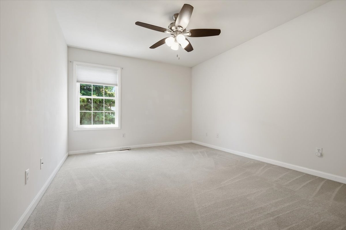 311 Old Farm Road Bloomington, IL 61704 - Photo 21 of 34 an empty room with a window and a ceiling fan