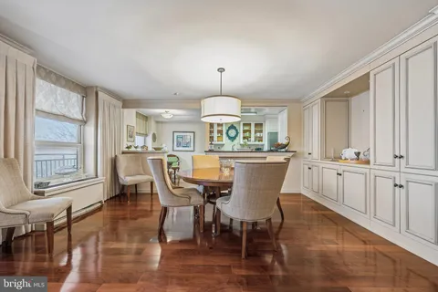 a dining room with furniture a chandelier and wooden floor