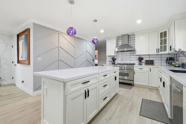 a kitchen that has a lot of cabinets in it and wooden floor